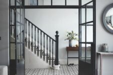 elegant black doors plus a transom window on top let the foyer receive more natural light and add interest to the space