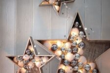 plywood stars filled with white and silver ornaments and lights are cute and chic festive decor options