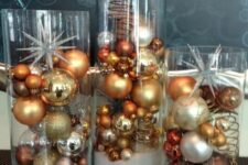 tall glasses with faux snow and bold metallic and clear Christmas ornaments are a lovely arrangement to display your ornaments