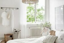 07 a neutral Scandinavian bedroom with white furniture, a pendant woven lamp, neutral bedding and some greenery