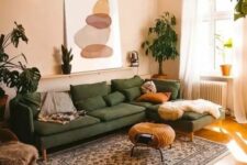 08 a muted and warm-colored living room with tan walls and a ceiling, a green sectional, a woven pouf, a printed rug and potted plants
