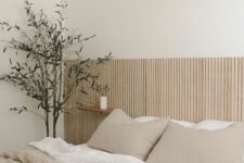 09 a neutral minimalist bedroom with an extended wood slat headboard, neutral bedding, floating nightstands and a potted plant