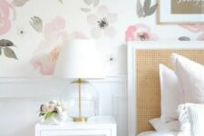 11 a lovely bedroom with a watercolor floral wall, a bed with a rattan headboard, white nightstands, gold touches