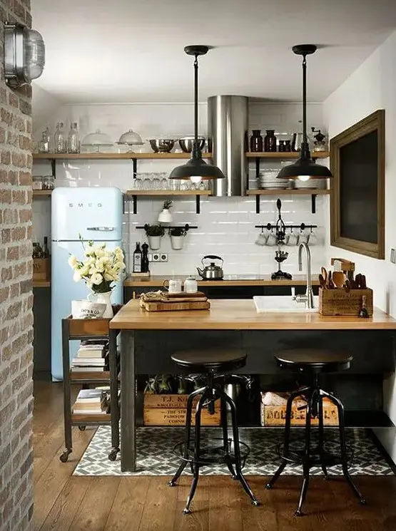 A kitchen island of blackened metal, with storage shelves and a light colored wooden tabletop plus a matching cart