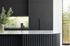 14 a matte black kitchen with no handles, a window backsplash, a curved and ridged black kitchen island with a white stone countertop