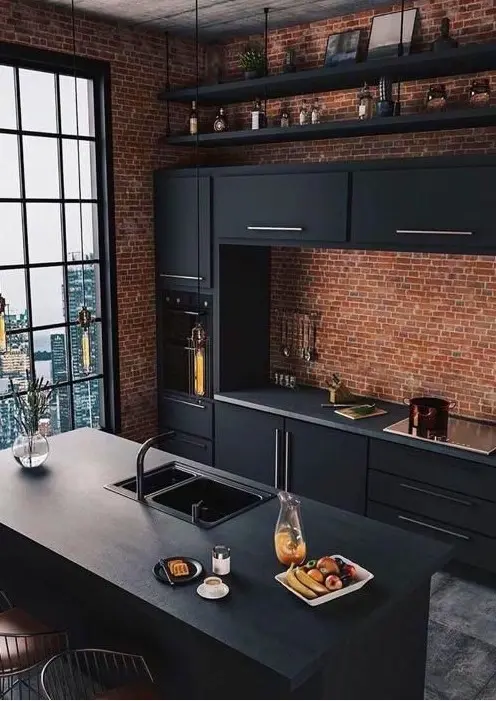 a moody and bold kitchen with red brick walls, sleek black cabinetry, black shelves and pendant lamps hanging