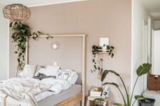 20 a lovely Scandi bedroom with a blush accent wall, a wooden bed and a stool, potted plants and a woven pendant lamp
