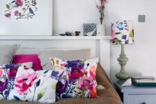 30 a modern neutral bedroom spruced up with bold floral pillows, a blanket, an artwork and a lamp with a floral lampshade