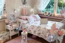 32 a pink and white shabby chic bedroom with a forged bed, white furniture, pink and floral bedding, candle lanterns and a crystal chandelier