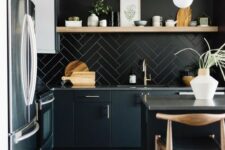 33 a contemporary moody kitchen with sleek black cabinetry, a black tile backsplash, a wooden shelf and wooden stools and pendant lamps