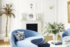 42 a charming living room with a curved blue sofa and matching chairs and a bold table that catch an eye