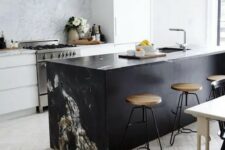 44 a modern white kitchen and a black kitchen island, a marble backsplash and countertop to tie them up