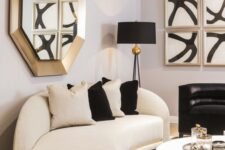 45 a refined space with a curved white and black sofa, gold touches and bold artworks is an amazing living room