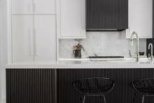 52 an elegant and laconic black and white kitchen with white and black reeded cabinets and a matching kitchen island plus black stools