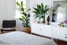 53 a boho bedroom with two statement plants that catch an eye and refresh the space