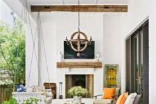 77 a lovely modern farmhouse outdoor living room with a fireplace, a suspended daybed, modern chairs, potted plants and blooms and a wooden chandelier