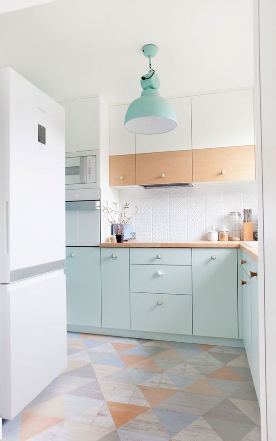 a Scandinavian kitchen with white, stained and mint blue cabinets, a white textural backsplash, stained countertops, a geo floor
