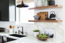a black and white kitchen with shaker cabinets, a white quartz countertop and a backsplash and open shelves
