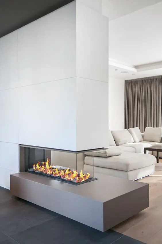 a chic contemporary living room with a neutral sofa, a dark coffee table, a minimalist fireplace and taupe curtains