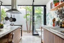 a cool indoor-outdoor kitchen with ribbed cabinets, concrete countertops, a large matching kitchen island with an eating zone