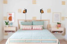 a cool pastel bedroom with a pink ceiling, a light-stained bed and nightstands, pastel bedding, blue and white poufs