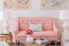 a feminine living room with a pink loveseat and grey chairs, a neutral ottoman, a floral rug and pastel watercolors is amazing