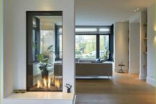 a minimalist white double-sided fireplace with an additional seat by its side is a cool idea to enjoy fire from all sides