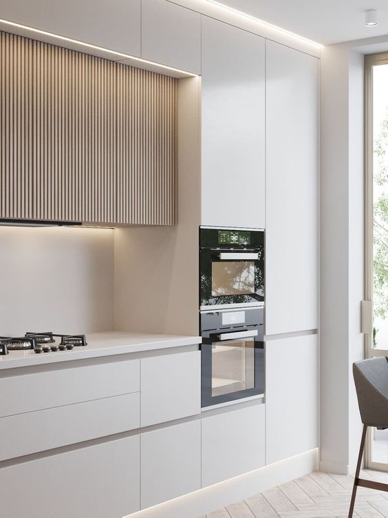 a minimalist white kitchen with sleek cabinets and light-stained ribbed upper cabinets with lights is a lovely idea