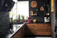 a moody black kitchen with faux brik walls, black countertops plus MDF cabinets and touches of yellow