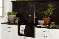 a neutral farmhouse kitchen with a black marble backsplash and countertops plus a black built-in sink