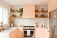 a peachy pink kitchen with plywood facades, a white stone countertop and a backsplash, open shelves and potted plants
