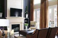 03 a chic modern living room with black and white walls, a window over the doors, a fireplace and a TV, dark seating furniture