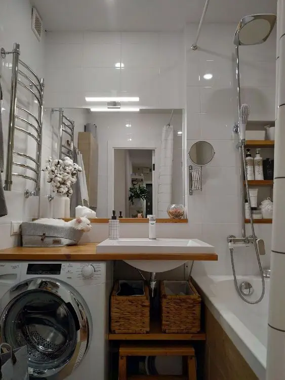 A modern white bathroom with a bathtub, an open timber vanity with a washing machine, a mirror and built in shelves
