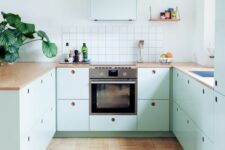 08 a lovely mint blue Scandinavian kitchen with plywood cabinets, butcherblock countertops, a square tile backsplash and pendant bulbs