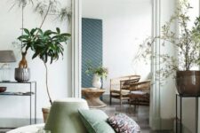 10 a beautiful space with large round sage green ottoman and potted plants is a very relaxed and airy space