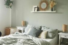 11 a boho sage green bedroom with white furniture, woven lamps, a ledge with a mirror, a woven pendant lamp and sage green bedding