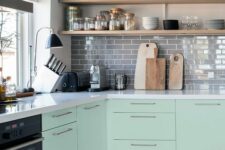 13 a mint green Scandinavian kitchen with grey tiles, white stone cabinets, open shelves, black lamps is a very cool space