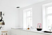 15 a simple minimalist kitchen with sleek white cabinets and white countertops plus some black touches for drama
