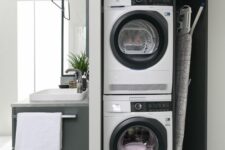 18 a compact concealed laundry area combining washing machine, dryer and ironing table in a single unit in a bathroom
