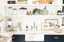 19 a beautiful black farmhouse kitchen with shaker cabinets, floating shelves, retro sconces and mixed metals for more eye-catchiness