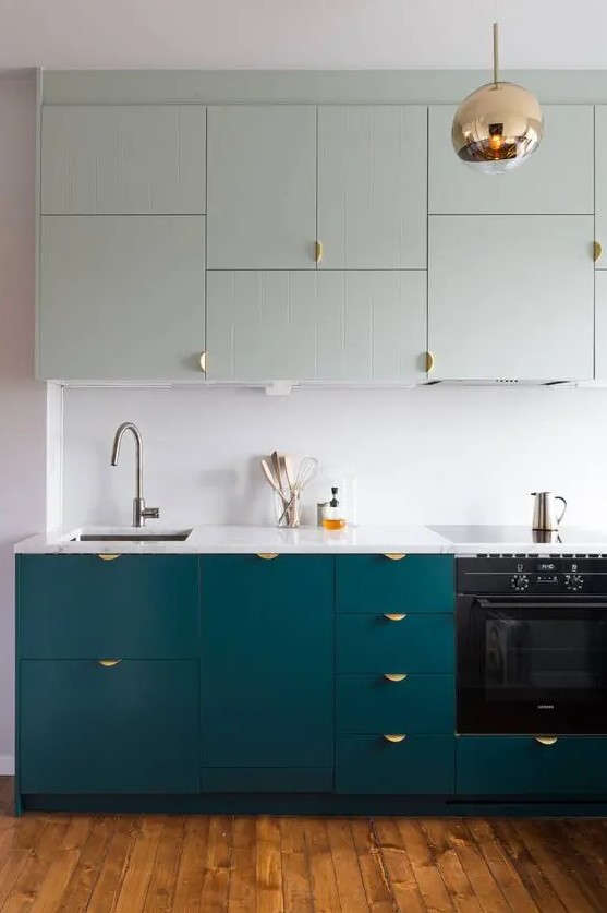 a teal and mint modern kitchen with a white backsplash and copper touches looks bold and chic