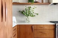 21 a beautiful mid-century modern kitchen with stained cabinets, a white tile backsplash and white countertops, greenery for a fresh look