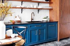 22 a bright blue kitchen with shaker lower cabinets, black countertops, long open shelves and a white herringbone tile backsplash is amazing
