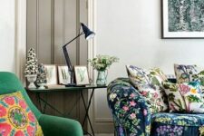 22 a neutral living room with a moody sofa, an emerald chair, a console table and moody floral artwork
