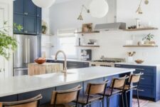 23 a bright modern kitchen with bold blue lower cabinets and a kitchen island, white countertops and a backsplash