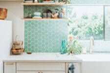 24 a white farmhouse kitchen with mint green hexagon tiles, open shelves, white countertops and potted plants is a chic space