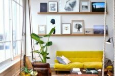 28 a double-height living room with a ledge gallery wall, a mustard sofa, leather chairs, coffee tables and potted plants