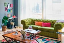 29 a bright living room with a console table and a colorful frame gallery wall, a green sofa, a bright floral rug and coffee tables