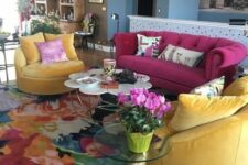 31 a colorful living room with a fuchsia sofa and yellow chairs, a super bold floral print rug and mismatching coffee tables