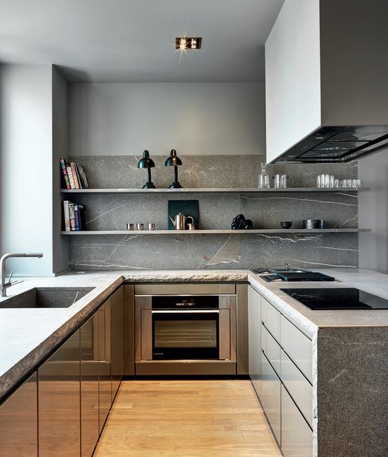 A minimalist grey kitchen with stone countertops and a backsplash plus open shelves instead of upper cabinets and built in appliances